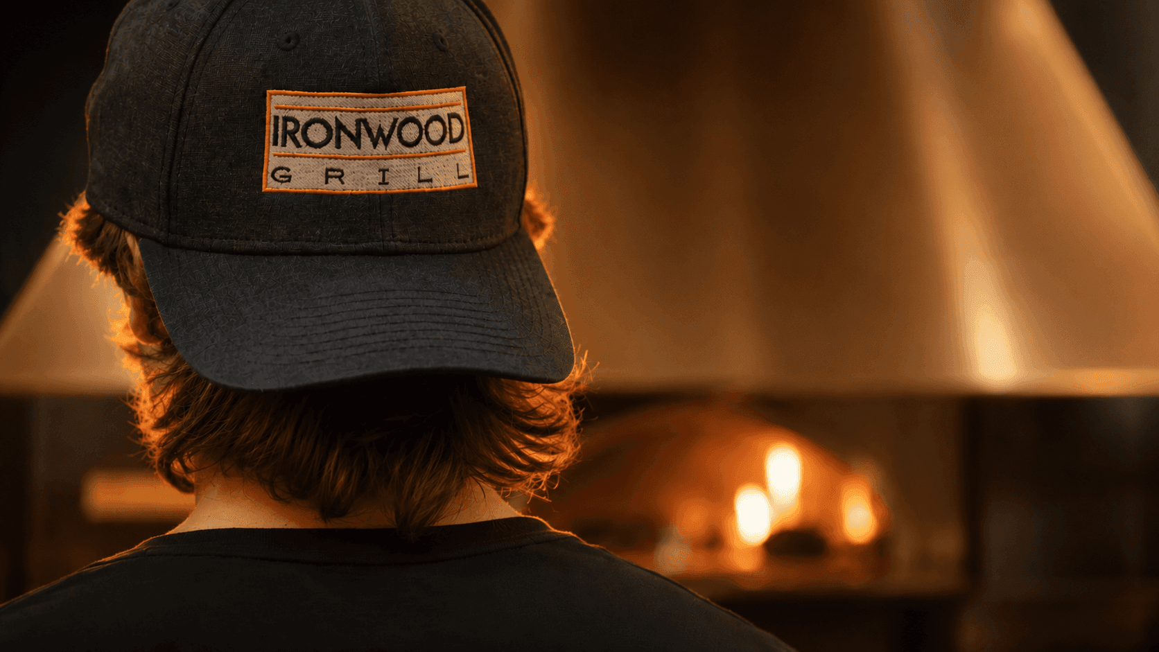 Man in an Ironwood Grill hat at the pizza oven
