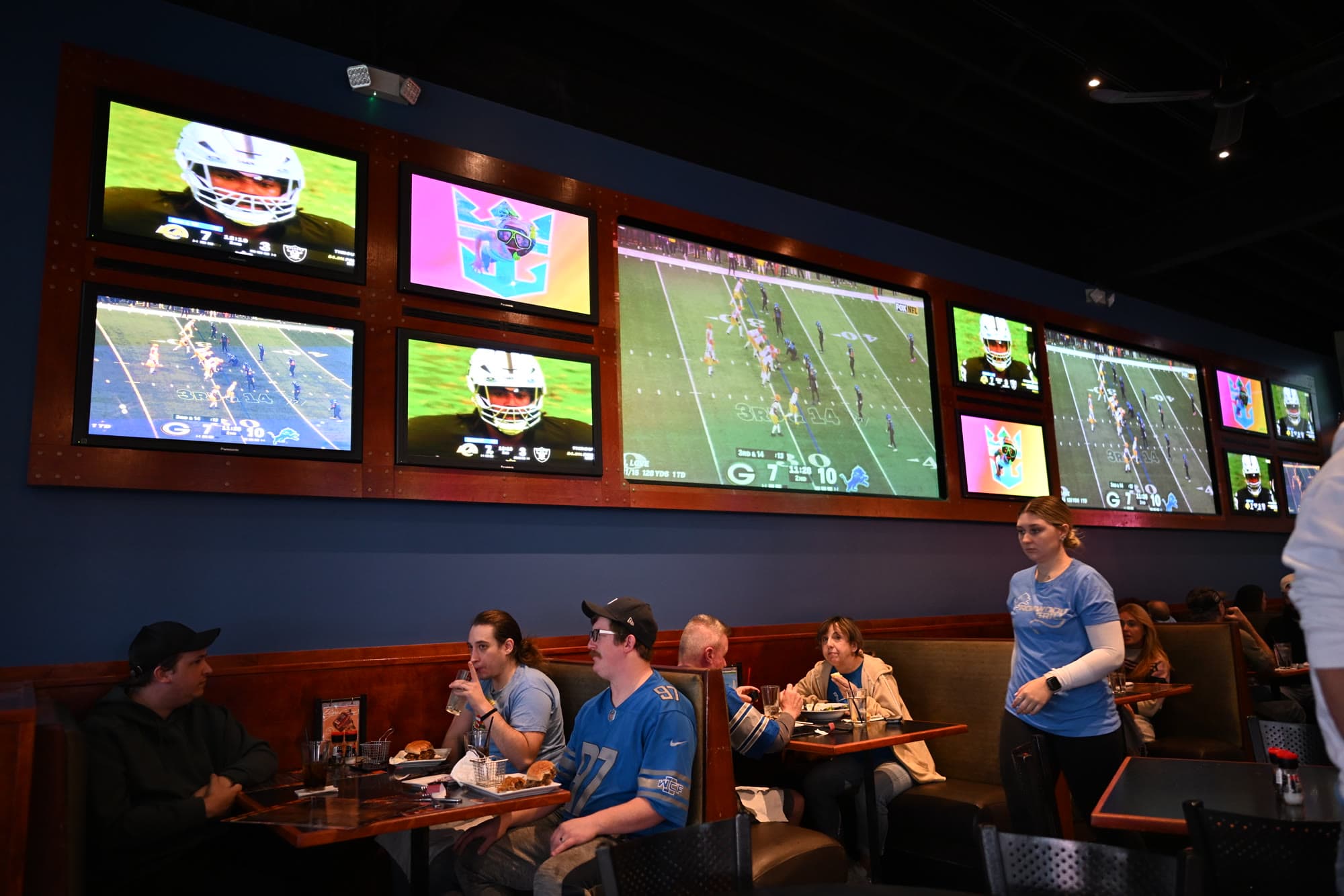 A row of TVs over the booth seating